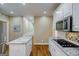 Modern kitchen with white cabinetry, a stainless steel microwave, and a granite-topped island at 1621 White Oak Cv, Loganville, GA 30052