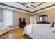 This is a spacious main bedroom with hardwood floors and a tray ceiling with a ceiling fan at 1621 White Oak Cv, Loganville, GA 30052