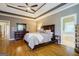 Spacious main bedroom with a tray ceiling, hardwood floors, and an ensuite bathroom at 1621 White Oak Cv, Loganville, GA 30052
