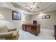 Home office featuring a large wooden desk, comfortable seating, and a tray ceiling with recessed lighting at 1621 White Oak Cv, Loganville, GA 30052