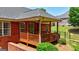Covered patio with wood railings, brick accents, and backyard views offers a cozy outdoor space at 1621 White Oak Cv, Loganville, GA 30052