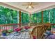 Relaxing covered patio featuring wood columns, ceiling fan, and comfortable seating with serene backyard views at 1621 White Oak Cv, Loganville, GA 30052