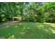 Exterior view of a home with a covered driveway and spacious front yard, surrounded by mature trees at 2257 Chestnut Log Loop, Lithia Springs, GA 30122