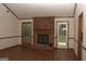 Spacious living room with a brick fireplace, wood trim, and a door to the backyard, and hardwood floors at 3857 Pointers Sw Way, Conyers, GA 30094