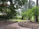 View of the wooded backyard with a brick path leading through the greenery and mature trees at 1283 Bramble Ne Rd, Atlanta, GA 30329