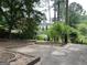 View of the serene backyard showcasing mature trees and a brick patio, perfect for relaxing outdoors at 1283 Bramble Ne Rd, Atlanta, GA 30329