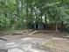 View of the private backyard featuring mature trees, a storage shed, and a brick patio, creating a peaceful outdoor retreat at 1283 Bramble Ne Rd, Atlanta, GA 30329