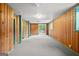 Spacious basement featuring wood paneling, neutral carpet, and sliding door access to exterior at 1283 Bramble Ne Rd, Atlanta, GA 30329