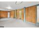 Spacious basement featuring wood paneling, neutral carpet, and door access to other rooms at 1283 Bramble Ne Rd, Atlanta, GA 30329