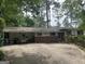Ranch-style home with brick accents, covered parking, and mature trees providing ample shade at 1283 Bramble Ne Rd, Atlanta, GA 30329