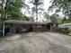 Ranch-style home with brick accents, covered parking, and mature trees providing ample shade at 1283 Bramble Ne Rd, Atlanta, GA 30329