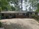 Ranch-style home with brick accents, covered parking, and mature trees providing ample shade at 1283 Bramble Ne Rd, Atlanta, GA 30329