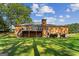 View of the backyard, showcasing a deck, brick exterior, and well-maintained lawn at 315 Burke Cir, Mcdonough, GA 30253