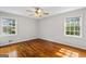 Spacious bedroom with gleaming hardwood floors, ceiling fan, and natural light from large windows at 315 Burke Cir, Mcdonough, GA 30253