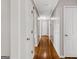 A long hallway with hardwood floors, multiple doors, and recessed lighting at 315 Burke Cir, Mcdonough, GA 30253