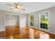 Sunlit living room with hardwood floors, ceiling fan, and large windows overlooking the yard at 315 Burke Cir, Mcdonough, GA 30253