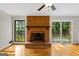 A living room boasts hardwood floors, a brick fireplace, and glass doors leading to the deck at 315 Burke Cir, Mcdonough, GA 30253