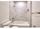 Bathroom with bathtub and shower featuring modern shower head and gray marbled tile at 1947 Clark Dr, Tucker, GA 30084