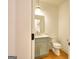 Stylish half bathroom with green vanity, marble countertop, pendant lighting, and hardwood floors at 1947 Clark Dr, Tucker, GA 30084