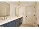 Modern bathroom with double sinks, gold fixtures and hardware, quartz counters, and a large mirror at 1947 Clark Dr, Tucker, GA 30084
