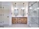 Modern bathroom featuring double sinks, light wood cabinets, sleek fixtures, and a glass-enclosed shower at 1947 Clark Dr, Tucker, GA 30084
