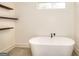 Modern bathroom features a freestanding tub, wood shelves, and neutral design at 1947 Clark Dr, Tucker, GA 30084
