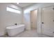 Elegant bathroom with modern tub, large window, and gray tiled floors at 1947 Clark Dr, Tucker, GA 30084