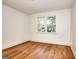 Cozy bedroom boasts hardwood floors, white walls, and a view of mature trees at 1947 Clark Dr, Tucker, GA 30084