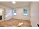 A bright bedroom features hardwood floors, white walls, and two large windows at 1947 Clark Dr, Tucker, GA 30084