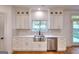 Bright kitchen boasts stainless steel appliances, white cabinets, and wooden floors at 1947 Clark Dr, Tucker, GA 30084