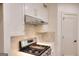 Close-up of the stovetop and sleek stainless steel range hood in this modern kitchen at 1947 Clark Dr, Tucker, GA 30084