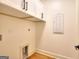 Bright laundry room features white cabinets, modern fixtures, and hardwood floors at 1947 Clark Dr, Tucker, GA 30084