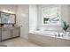 Relaxing bathroom features a soaking tub, light colored cabinets, and tile flooring at 247 Widener Way, Peachtree City, GA 30269