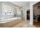 This ensuite bathroom boasts a soaking tub, glass shower, and bright window views at 247 Widener Way, Peachtree City, GA 30269