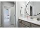 Bathroom featuring a round mirror, chrome faucet, gray cabinets and tiled floors at 247 Widener Way, Peachtree City, GA 30269