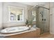 This luxury bathroom offers a soaking tub, separate shower, and a bright window at 247 Widener Way, Peachtree City, GA 30269