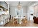 Bright dining room with modern white table, wood chairs, and decorative chandelier lighting fixture at 247 Widener Way, Peachtree City, GA 30269