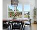 Dining area with a live edge wood table, black chairs, and lots of light from large windows overlooking the backyard at 247 Widener Way, Peachtree City, GA 30269