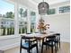 Bright dining room with a live edge dining table, black chairs, and large windows with neighborhood views at 247 Widener Way, Peachtree City, GA 30269