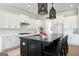 Bright kitchen featuring white cabinets, stainless steel appliances, and black island with pendant lighting at 247 Widener Way, Peachtree City, GA 30269