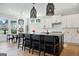 Modern kitchen with large black island, pendant lighting, white cabinets, and adjoining breakfast area at 247 Widener Way, Peachtree City, GA 30269