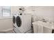Bright laundry room featuring a large washer and dryer, utility sink, and stylish tile floor at 247 Widener Way, Peachtree City, GA 30269