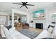 Open-concept living room featuring a white sofa, brick fireplace with mounted TV, and view of dining area at 247 Widener Way, Peachtree City, GA 30269