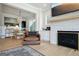 Open-concept living area with fireplace, TV, view of dining area, and a comfortable leather chair at 247 Widener Way, Peachtree City, GA 30269