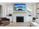Living room featuring a modern fireplace, built-in cabinets, and a mounted TV with a serene beach scene at 247 Widener Way, Peachtree City, GA 30269