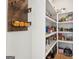 Well-stocked walk-in pantry with white shelving and wooden accents and loaded with food at 247 Widener Way, Peachtree City, GA 30269