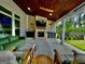 Relaxing covered patio featuring an outdoor fireplace, comfortable seating, ceiling fans, and a view of the backyard at 247 Widener Way, Peachtree City, GA 30269
