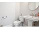 Neutral powder room featuring white fixtures, a pedestal sink and a round mirror at 247 Widener Way, Peachtree City, GA 30269