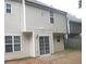 Back exterior view of the house with a small patio and a sliding glass door at 4383 Chestnut Lake Ave, Lithonia, GA 30038