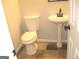 Cozy bathroom featuring a classic toilet and a pedestal sink with modern fixtures and neutral tones at 4383 Chestnut Lake Ave, Lithonia, GA 30038